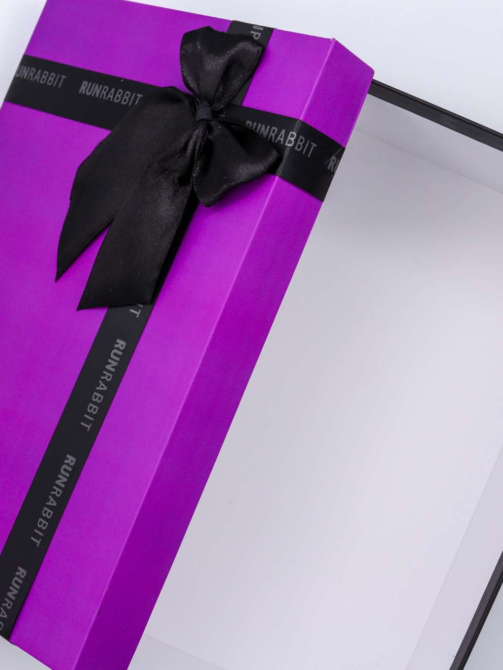 Purple gift box with a black ribbon and 'Run Rabbit' branding on a white background